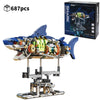 A detailed mechanical shark model built from interlocking plastic pieces, displayed on a stand.
