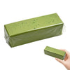 A rectangular green squishy butter stick fidget toy is shown being held by a hand.