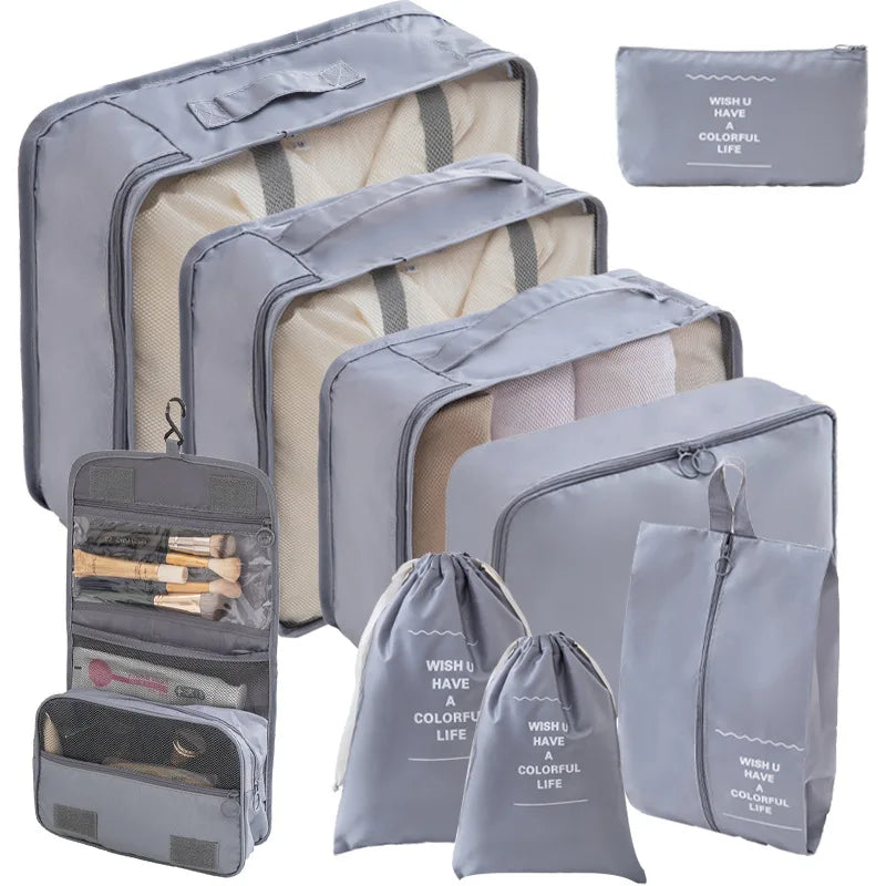 A set of gray travel packing cubes and storage bags for organizing items.