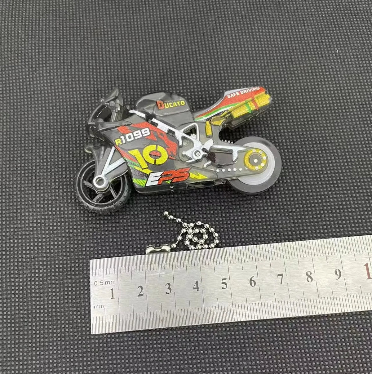 A detailed model of a Ducati motorcycle keychain fidget toy featuring red and yellow accents.