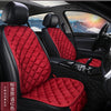 Interior view of a car seat with red quilted leather upholstery and black trim.