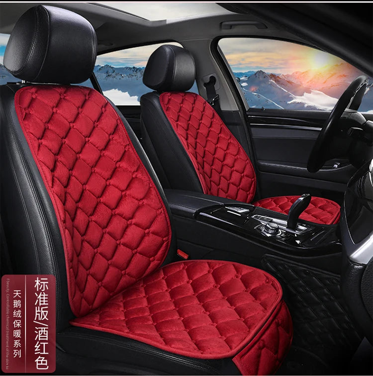 Interior view of a car seat with red quilted leather upholstery and black trim.