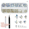 A clear plastic box containing various glass rhinestones, drill pens, and tweezers for nail art.