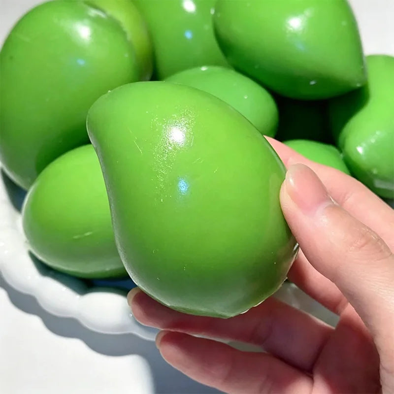 Une main tient un jouet anti-stress vert vif et ovale à la forme lisse.