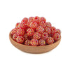 A pile of bright red and gold rhinestone resin bayberry ball beads in a wooden bowl.