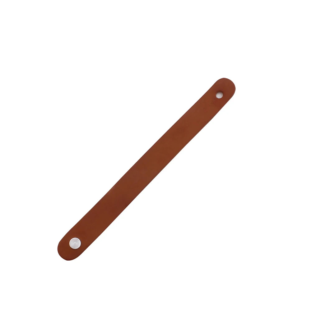 A brown leather guitar strap button with a metal fastener.