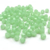 A pile of light green faceted bicone crystal glass beads for jewelry making