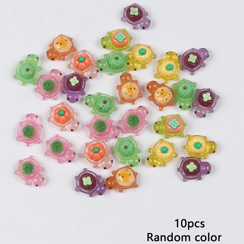 A collection of ten mini glow-in-the-dark turtle resin figurines in various colors scattered on a white background.