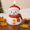A cute white snowman with a red hat and scarf is featured next to a lit candle and autumn leaves.