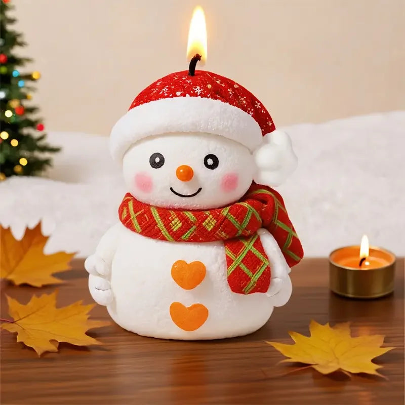 A cute white snowman with a red hat and scarf is featured next to a lit candle and autumn leaves.