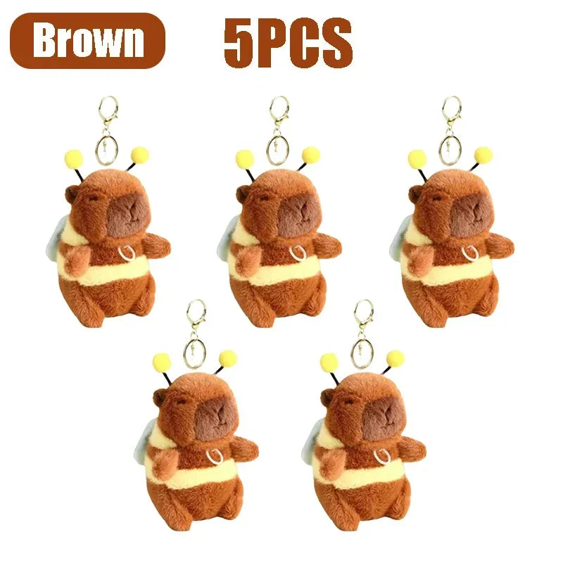 Five brown capybara plush toys with gold-colored keychain attachments