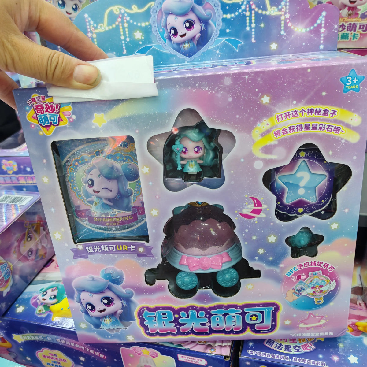 A box of Teenieping Shining Meteor Aurora Doll silver light collectible figures with a hand holding a white card.