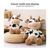 A classic multi-size display of adorable soft cow plush toys in black and white patterns.