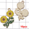 A set of ten gold-toned enamel flower charms featuring yellow and green petals and leaves.