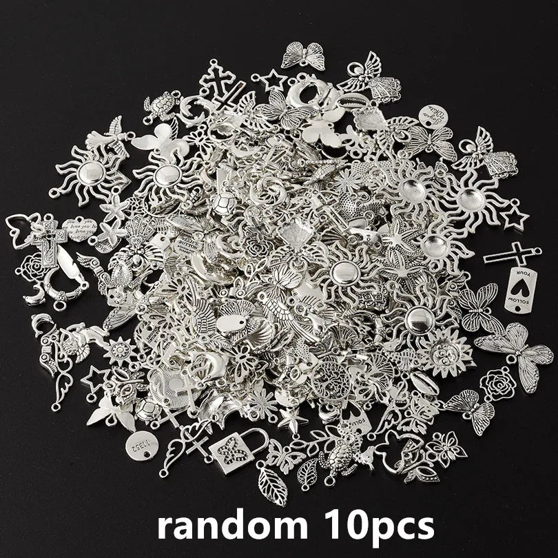 A pile of random silver metal charms and findings for DIY jewelry making
