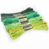 A set of multicolor embroidery floss skeins featuring a glitter finish in various shades of green and yellow.