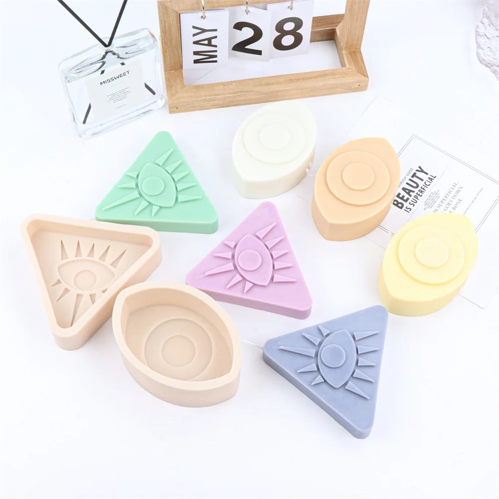 A collection of various colored 3D evil eye silicone molds for candles, soap, and resin art displayed on a white surface.