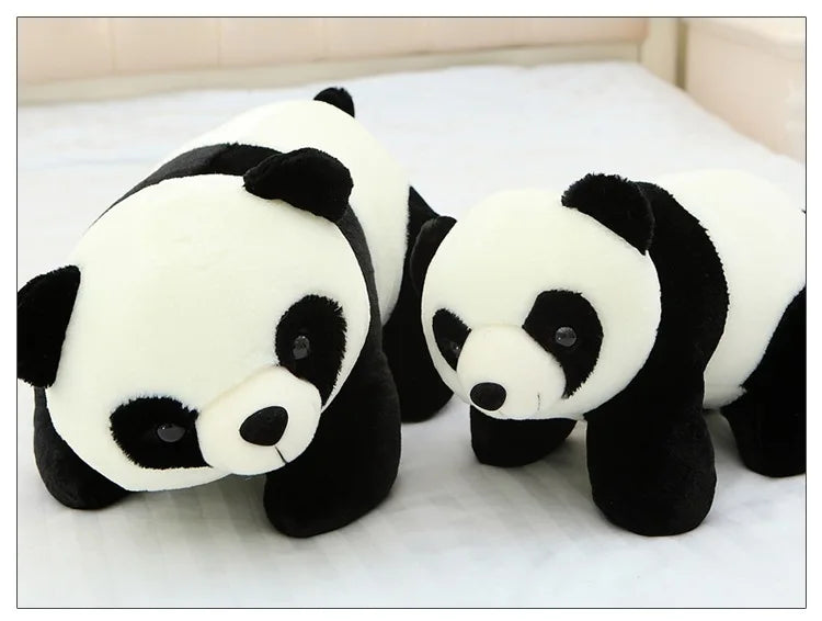 A white and black panda plush pillow lying on a white surface.