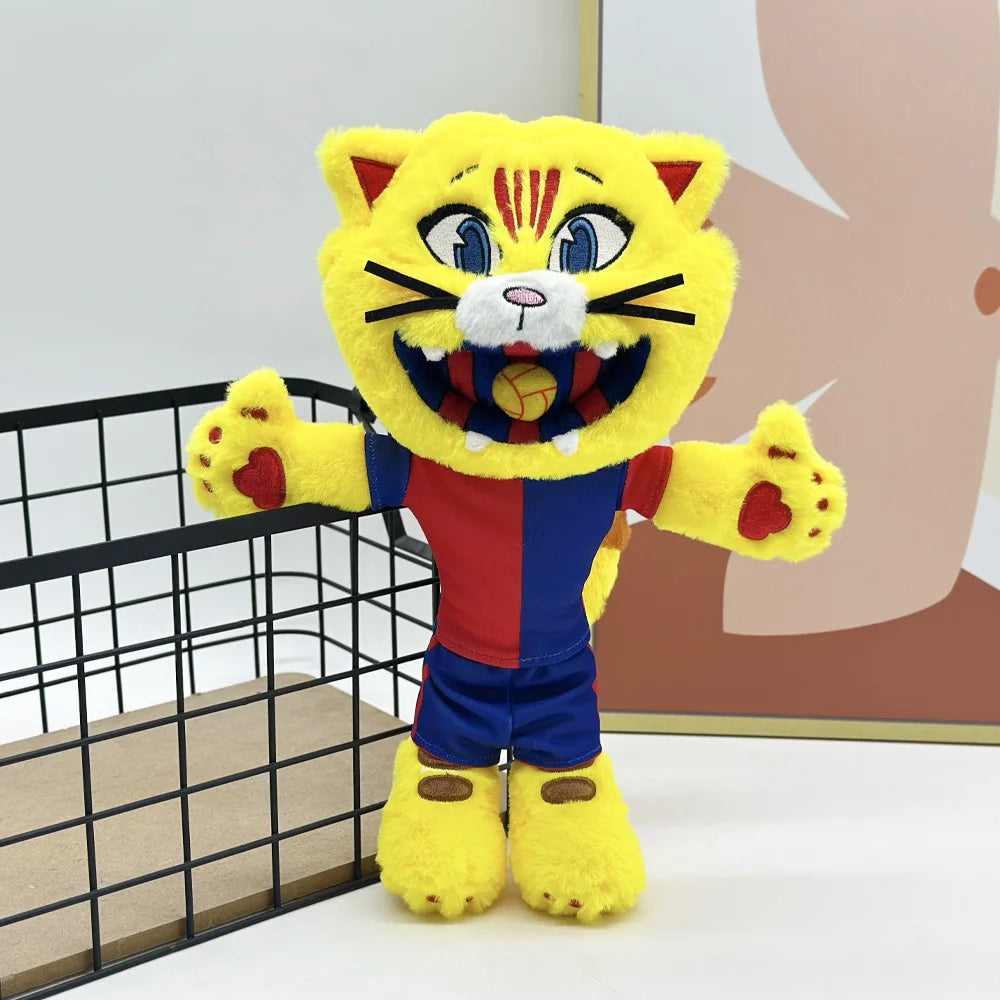 A yellow and orange cat mascot plush toy with striped face and football accents standing in front of a light background.