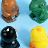 Three wind-up bouncing toys: an orange bear, a green dinosaur, and a yellow chick.