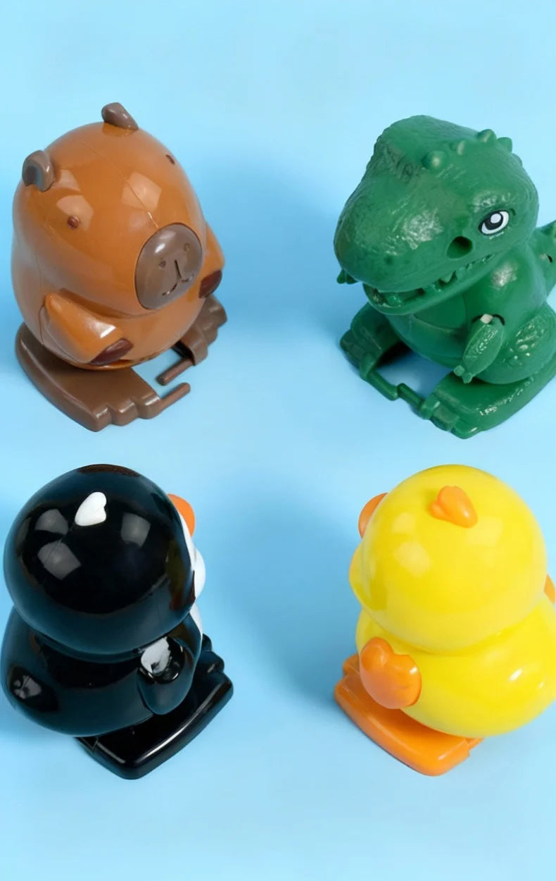 Three wind-up bouncing toys: an orange bear, a green dinosaur, and a yellow chick.