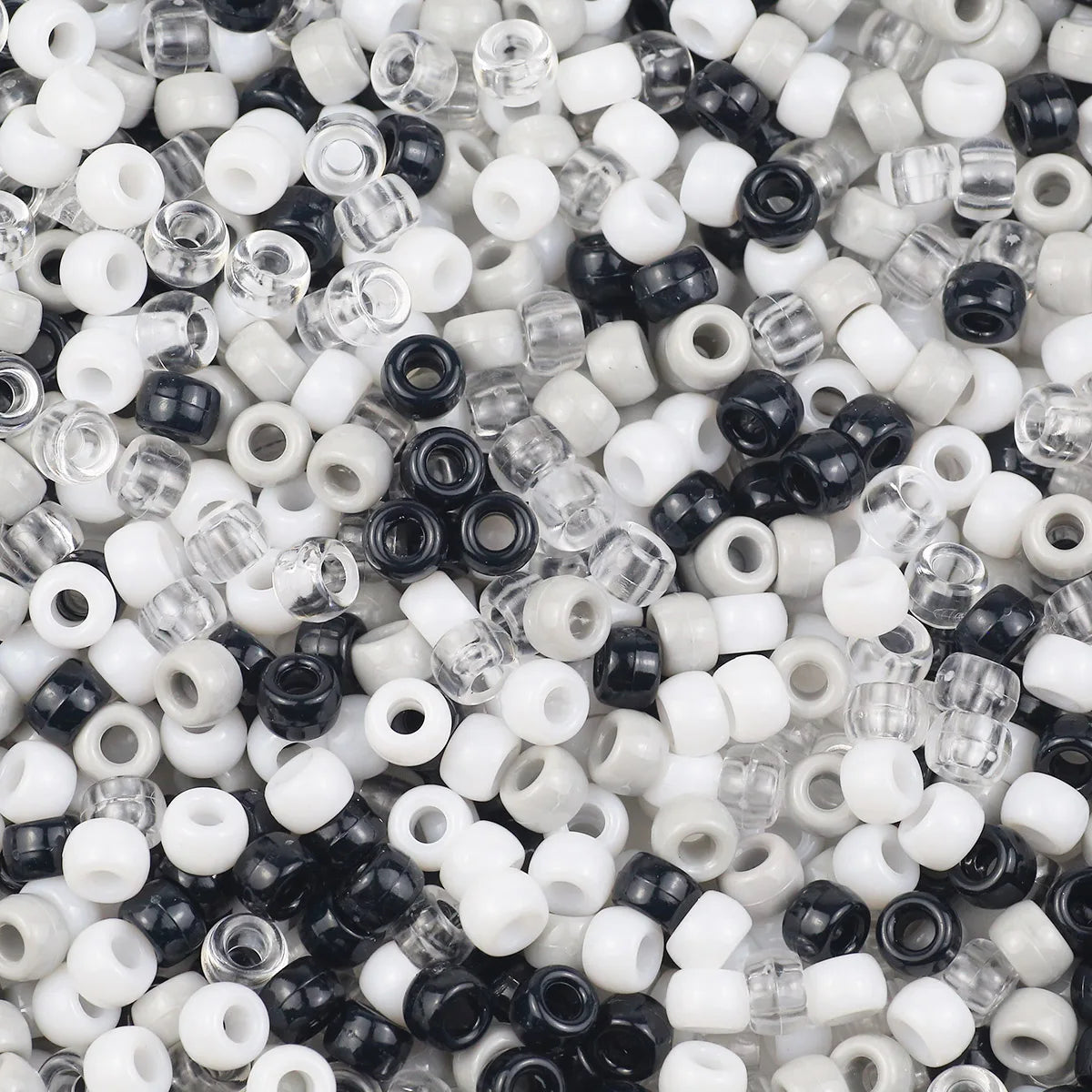 A close-up view of small, solid color pony beads in various sizes and finishes.