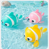 Three colorful wind-up swimming duck bath toys floating in clear water.