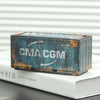 A miniature industrial iron storage box with an openable lid, showing weathered blue and orange metal.