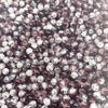 A close-up view of small, round glass crackle beads in shades of purple and clear.