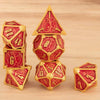 A set of seven premium metal polyhedral dice in red and gold are displayed on a wooden surface.