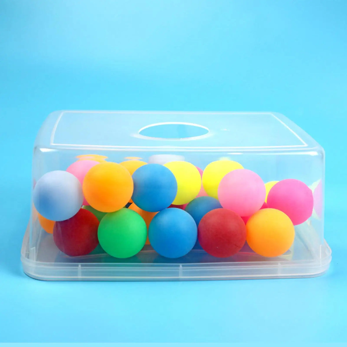 A clear plastic container filled with colorful spherical balls for a party game