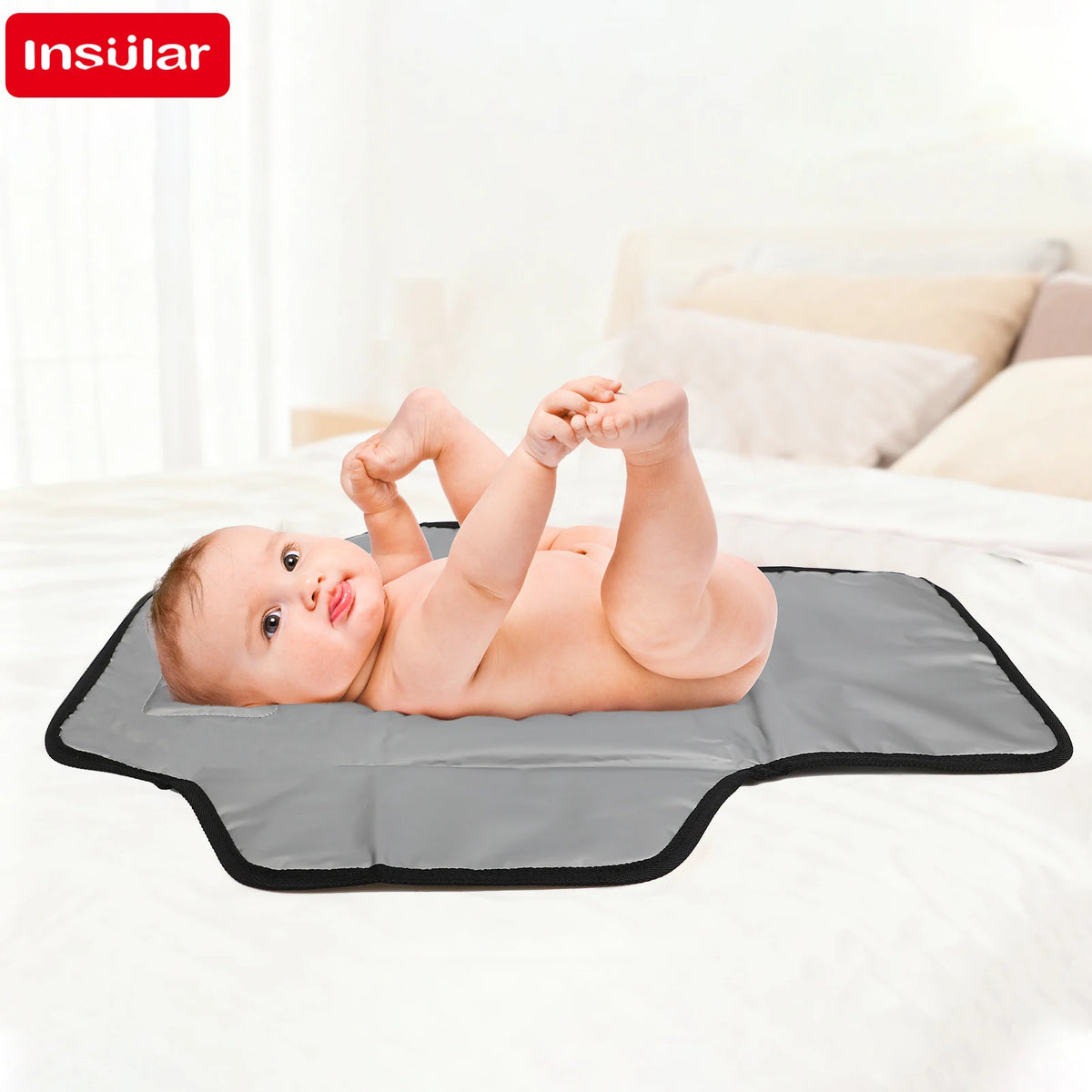 A baby is lying on a gray portable foldable waterproof diaper changing pad on a white bed.