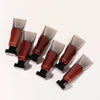 A set of Mafine Dark Mirror Lip Glaze tubes with black applicators shown from above.