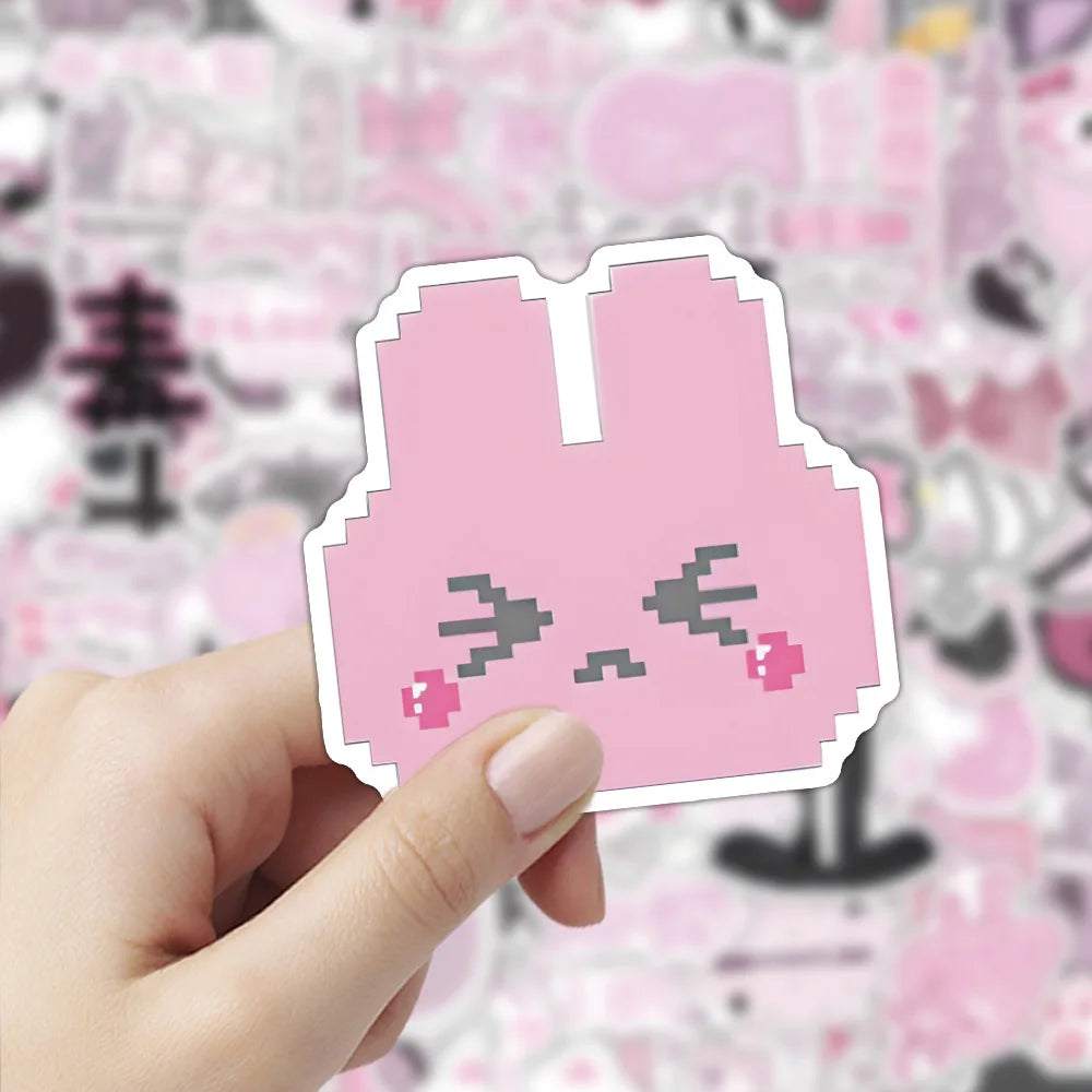A hand holds a pink, stylized rabbit sticker cutout against a light pink floral background.
