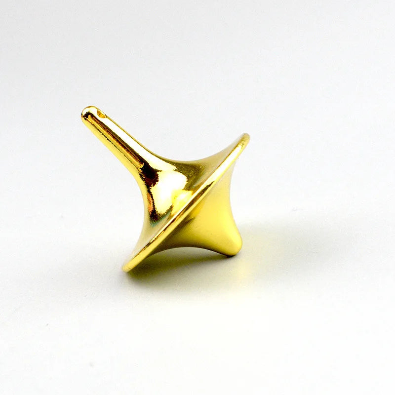 A small, golden metal fidget spinner with a smooth, tapered design resting on a white surface.