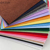 A stack of colorful non-woven felt fabric sheets in various shades of brown, blue, green, yellow, pink, and red.