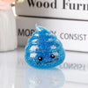 A bright blue glitter squishy stress ball shaped like a smiling face resting on a stack of white books.