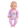 A baby doll wearing a pink unicorn pajama set with a floral print.