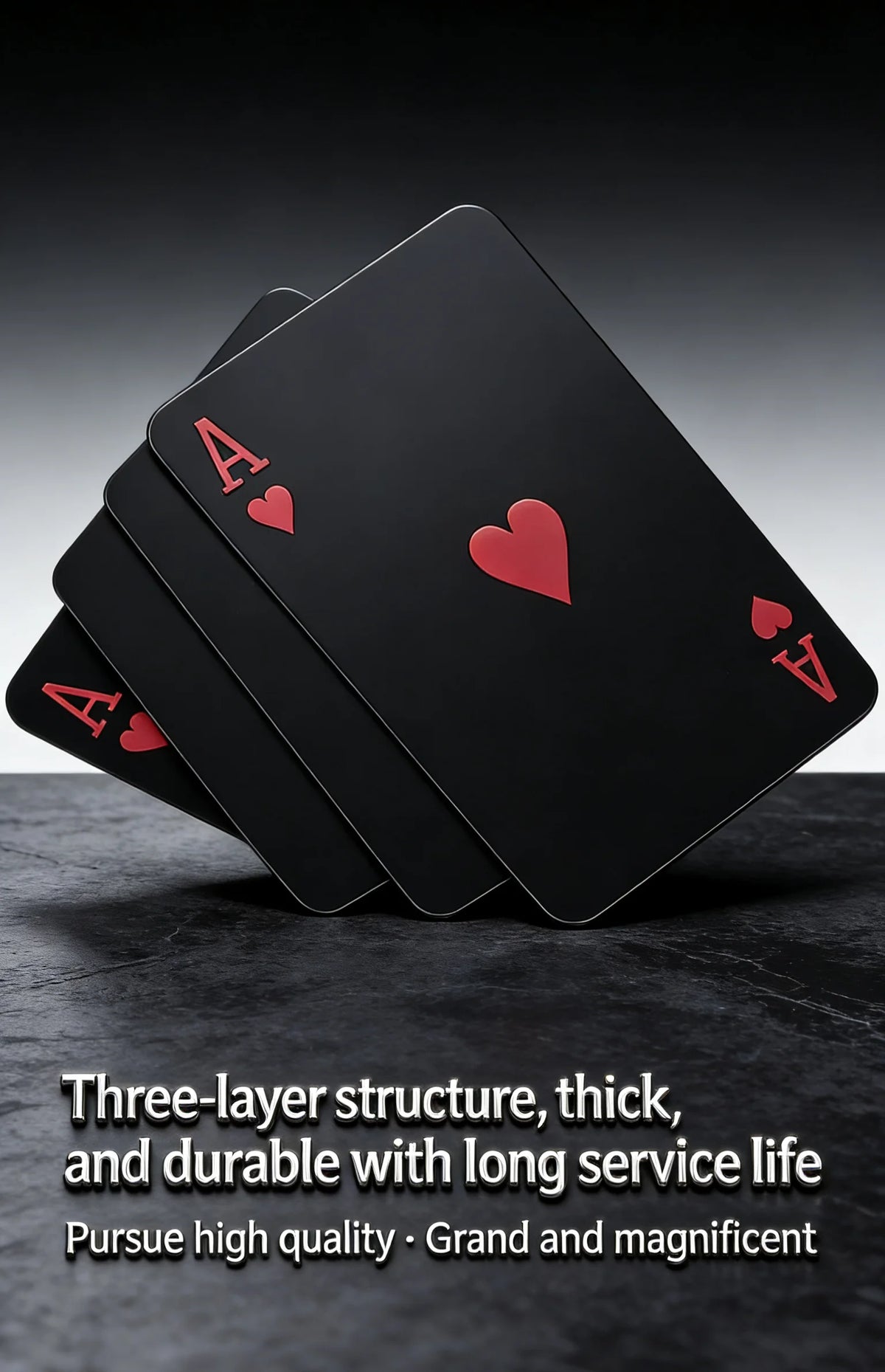A stack of black playing cards with red aces resting on a dark surface.