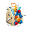 A wooden busy house toolbox featuring various tools and shapes for play, including a hammer, wrench, screwdriver, and gears.