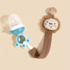 A light blue elephant pacifier holder with a clip and a brown fabric strap is shown against a beige background.