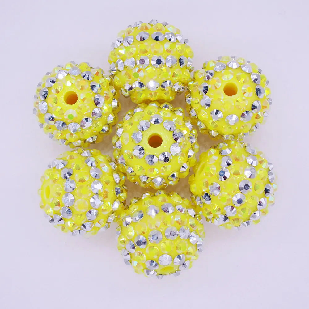 A pack of ten yellow and silver striped resin beads for jewelry making, shaped like small balls.