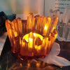 A glowing amber crystal silicone candle mold used for DIY resin crafts.