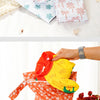 Two reusable waterproof baby wet bags in orange and white floral patterns are shown.