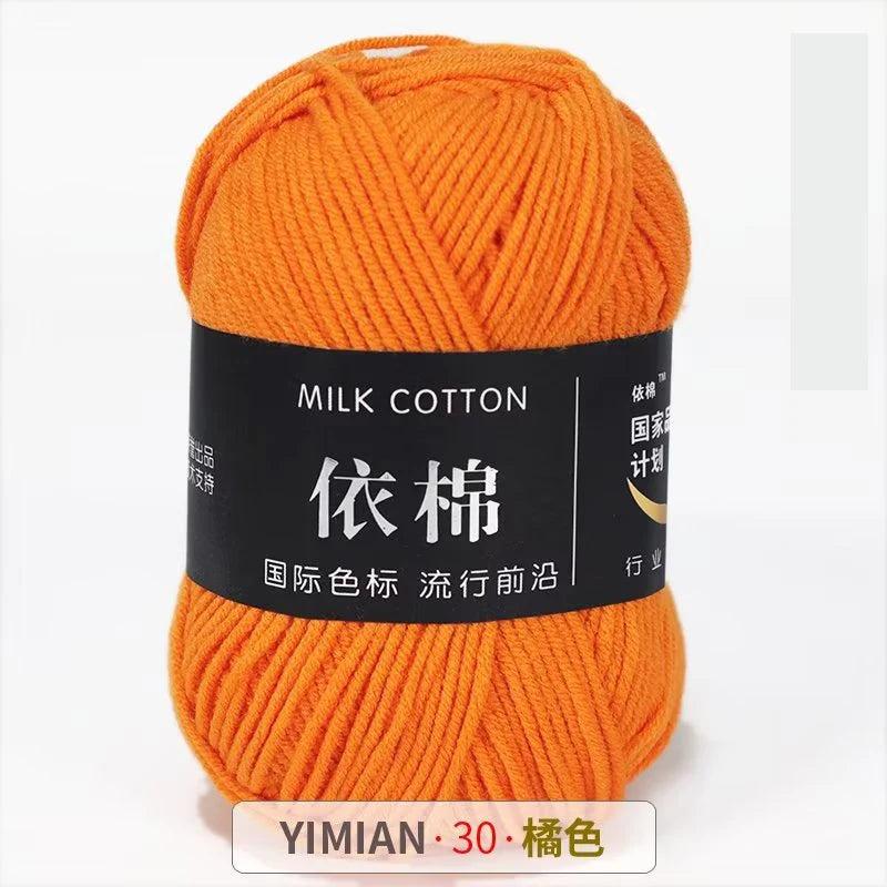 A ball of bright orange milk cotton yarn labeled YIMIAN 30 for knitting and crochet.