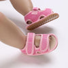Pink breathable first walker sandals for baby with a hook-and-loop closure shown on a child's foot.