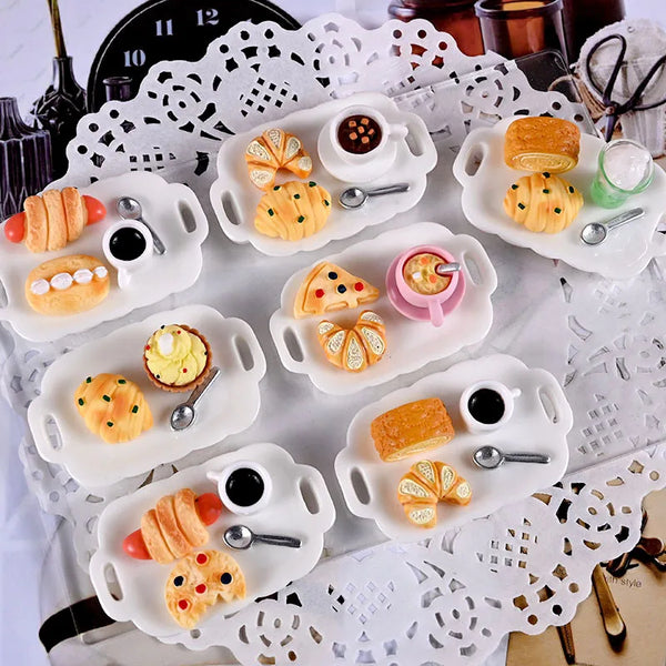 A set of 1:12 scale afternoon tea dollhouse featuring various pastries and tea accessories on white serving trays.