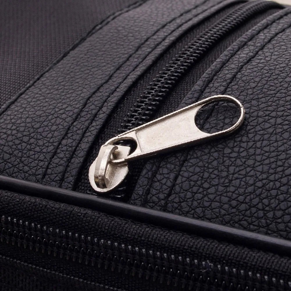 Close-up of a black padded guitar bag featuring a silver metal zipper pull.