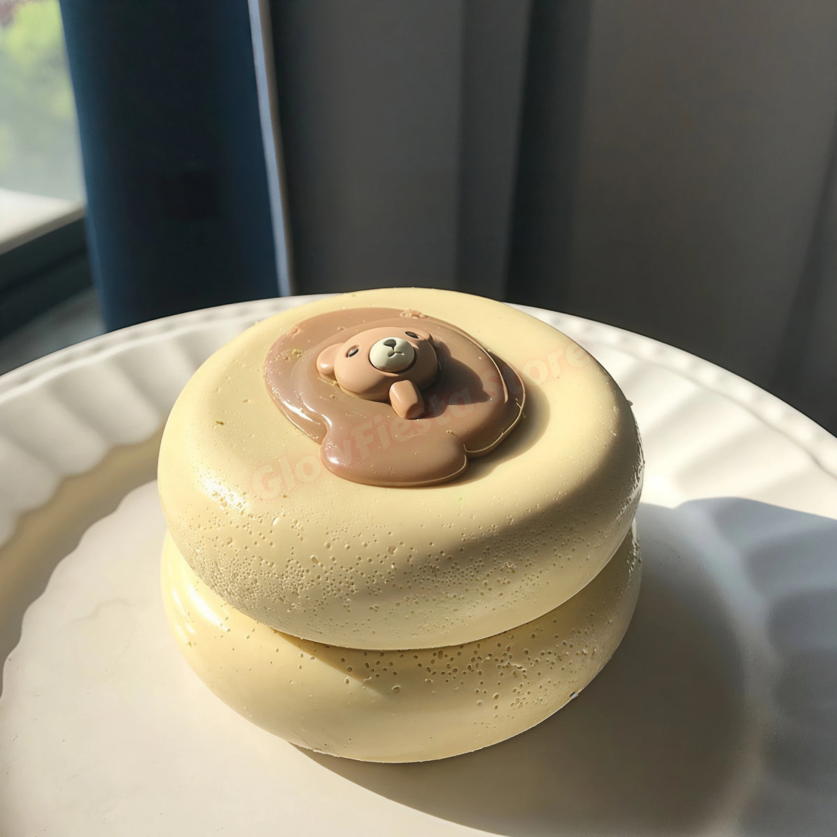 A round, light yellow creamy soufflé with a small, sculpted face on top, resting on a white plate.