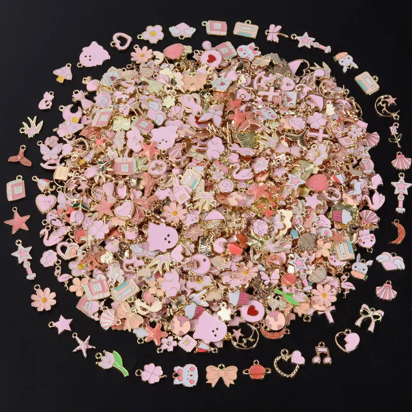 A close-up view of assorted metal pendants and charms in various pink, gold, and iridescent colors.